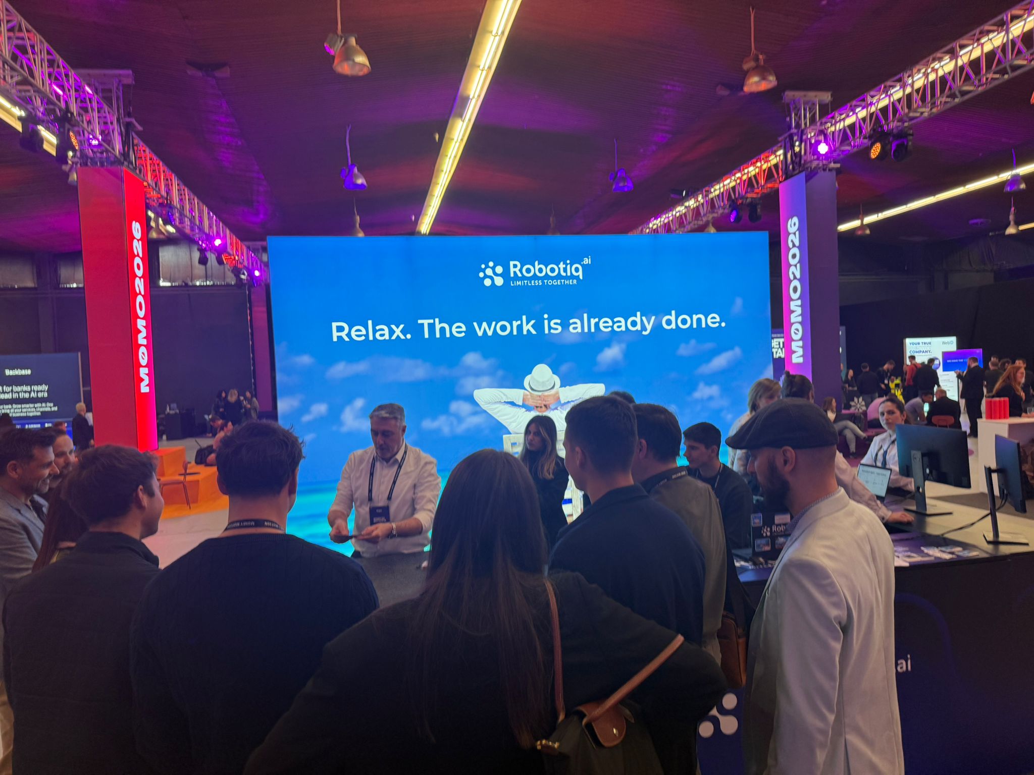 Crowd gathered around Robotiq booth during live magic performance at a trade show
